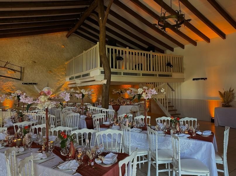 Salle de réception à poutres sublimée par un éclairage architectural ambré
