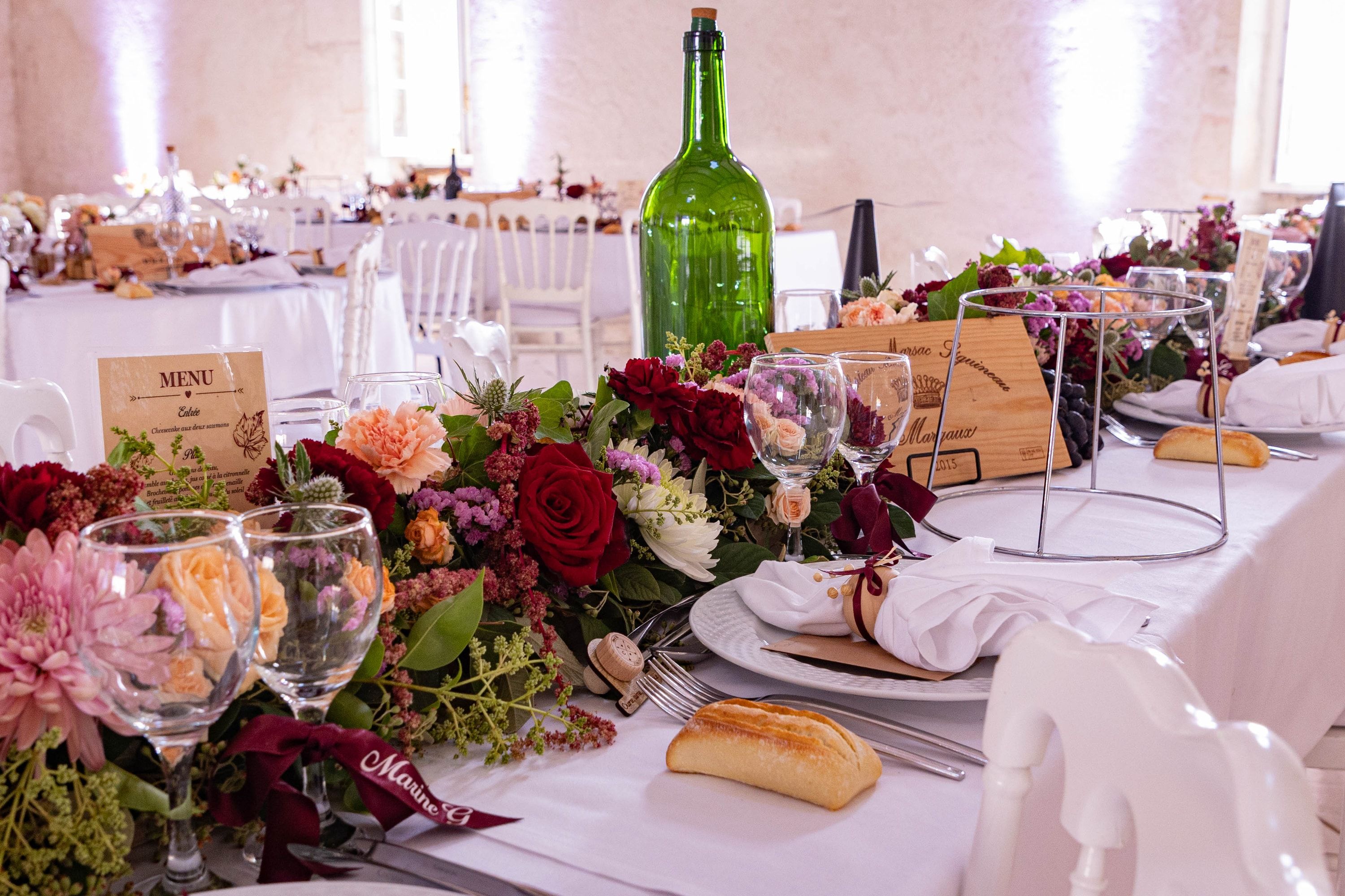 Table dressée et fleurie, dans une salle mise en lumière de violet